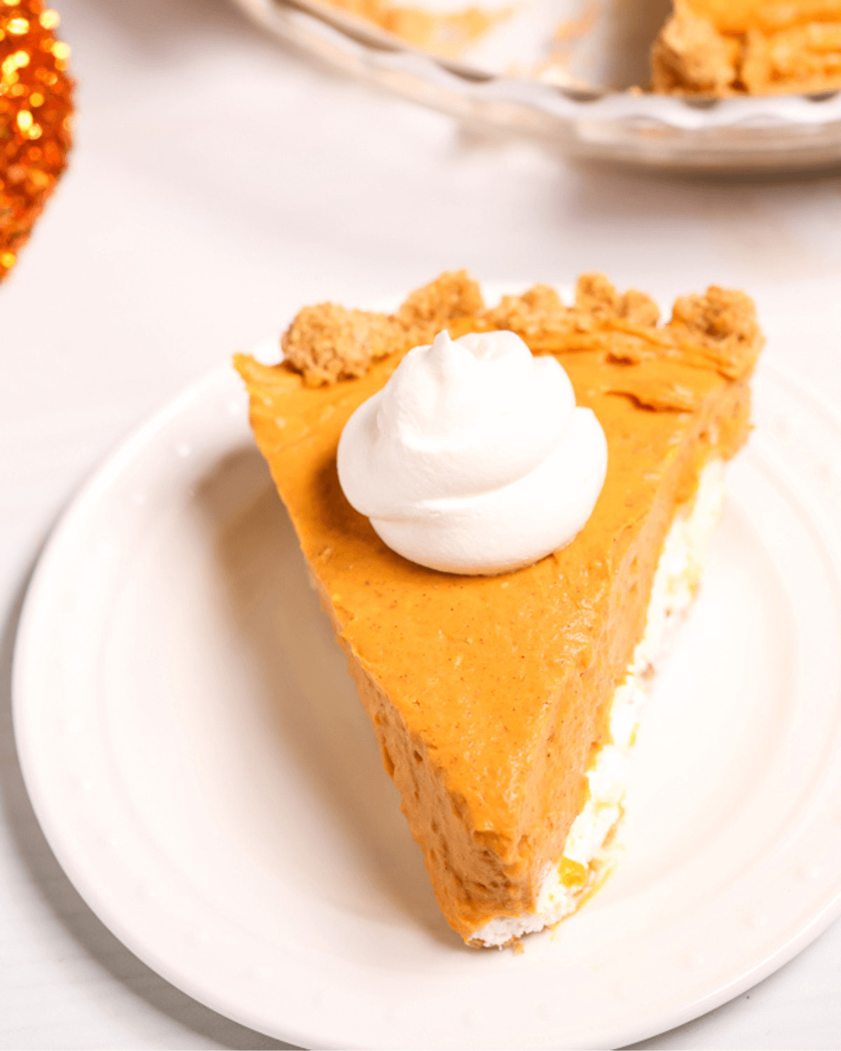 A white plate with the double layer cream cheese pumpkin pie.