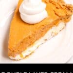 A slice of double layer cream cheese pumpkin pie, topped with whipped cream, is served on a white plate.