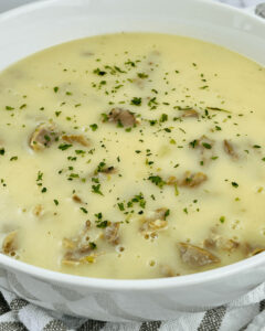 A large white bowl of giblet and turkey neck gravy.
