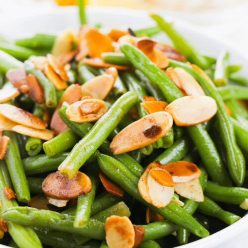 A bowl of green bean with slivered almonds.