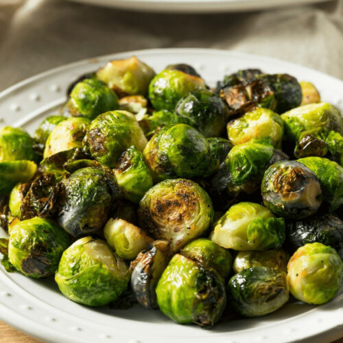 A white plate of Italian Brussel sprouts.