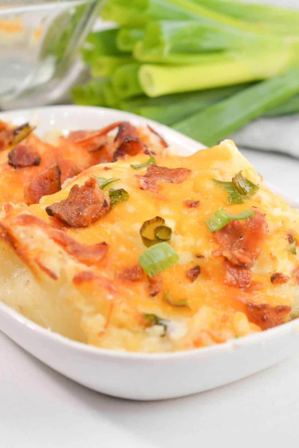 A white dish with the loaded mashed potato casserole.