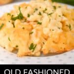 A serving of Old Fashioned Baked Macaroni and Cheese, garnished with chopped parsley, is presented on a white plate.