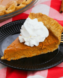 A slice of the old fashioned pumpkin pie with whipped cream.