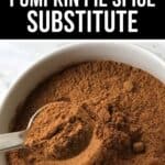 A bowl filled with Pumpkin Pie Spice Substitute, with a metal spoon scooping some of the fragrant spice blend.