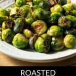 A plate of Roasted Brussels Sprouts with Parmesan Cheese is presented on a white dish, showcasing golden sprouts topped with freshly grated Parmesan. The text “Roasted Brussels Sprouts with Parmesan Cheese” appears below the plate.