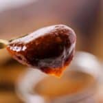 A close up of the spoon holding the sauce.