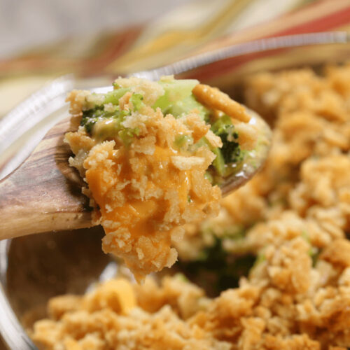 a spoon in the broccoli casserole with titz crsckers.