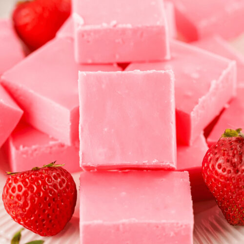 A stack of 2 Ingredient Strawberry Fudge decorated with fresh fruit.