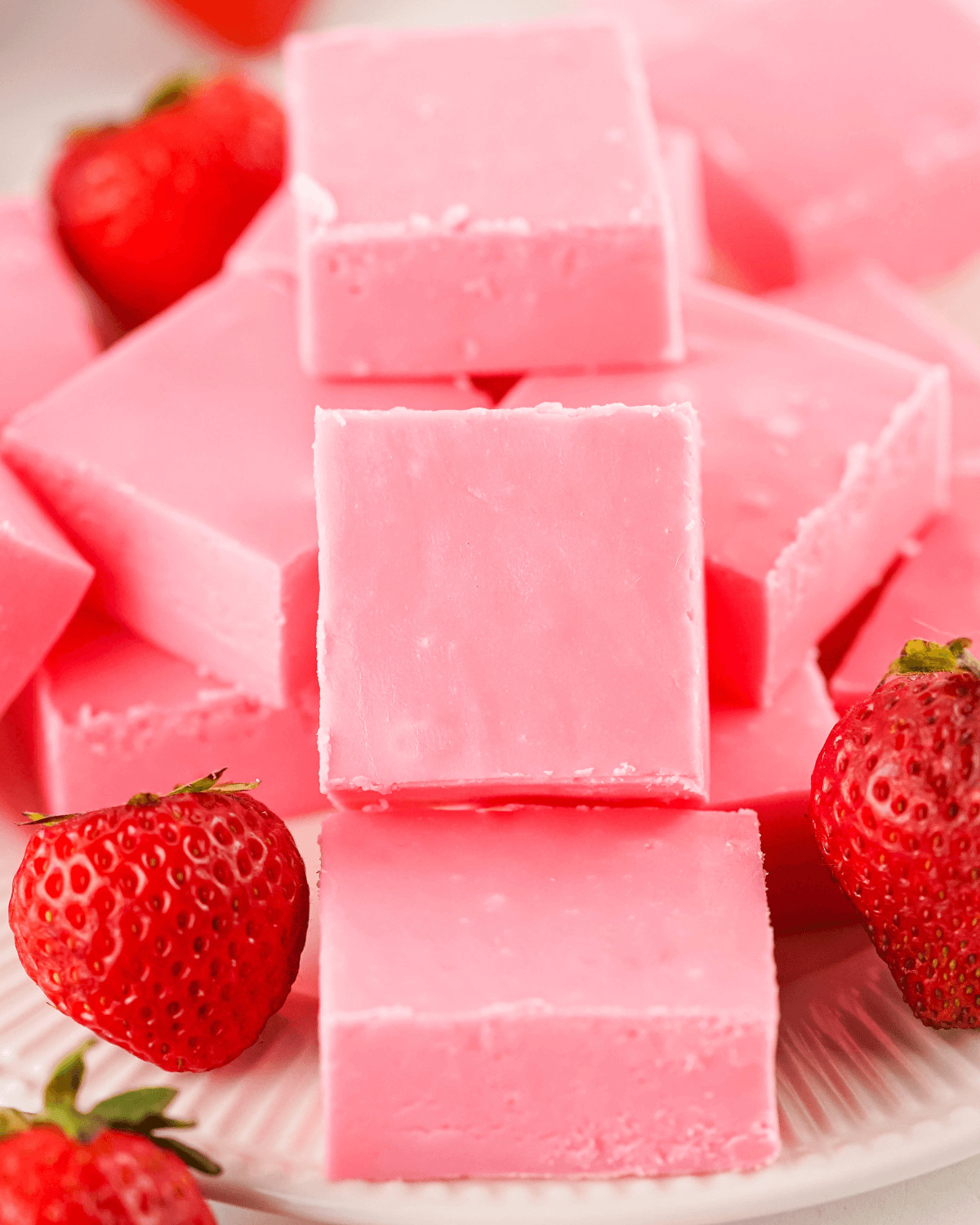 A stack of 2 Ingredient Strawberry Fudge decorated with fresh fruit.