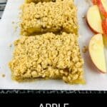 Three apple oatmeal bars sit on parchment paper beside several fresh apple slices. The text "APPLE OATMEAL BARS" is displayed at the bottom of the image, highlighting these delicious apple oatmeal bars.