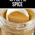 A glass jar filled with fragrant Apple Pie Spice powder, with a white spoon scooping some out; the label above reads "Easy Apple Pie Spice.