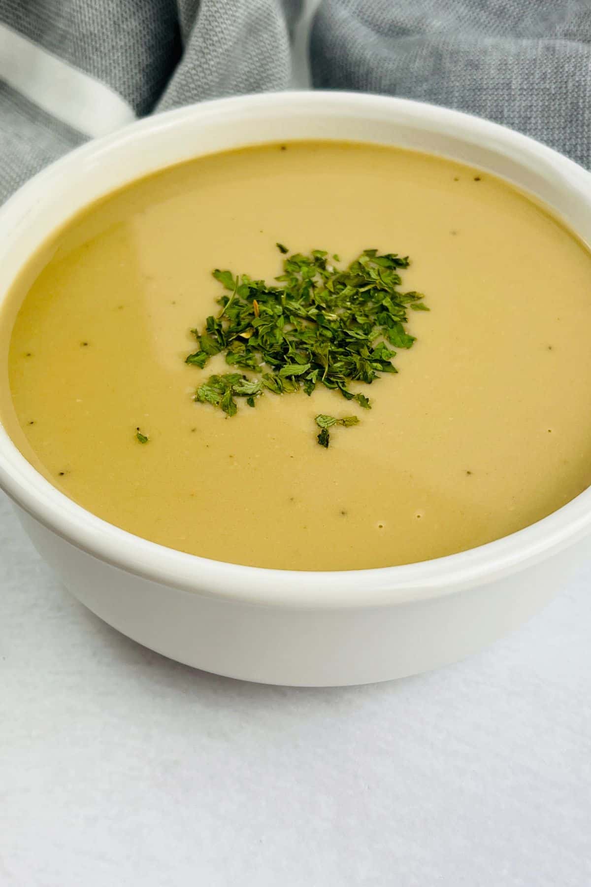 A white bowl filled with creamy sauce.