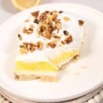 A slice of the lemon lush on a while plate.