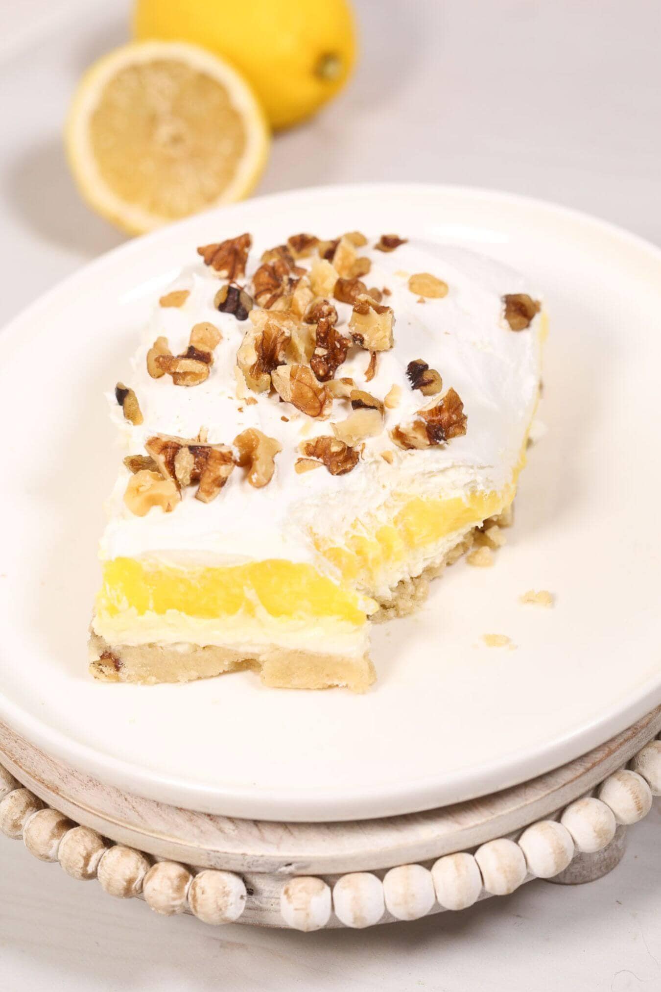 A slice of the lemon lush on a while plate.