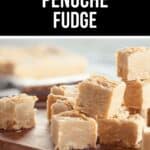 Cubes of creamy penuche fudge are stacked on a wooden board, with more rich pieces visible in the background.