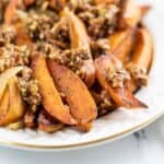 A plate of wedges topped with chopped pecans, served on a white dish.