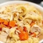 A close-up of a bowl of Slow Cooker Turkey Noodle Soup with tender shredded turkey, sliced carrots, and egg noodles in savory broth.