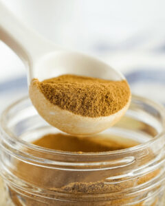 A spoon in the jar of apple pie spice.