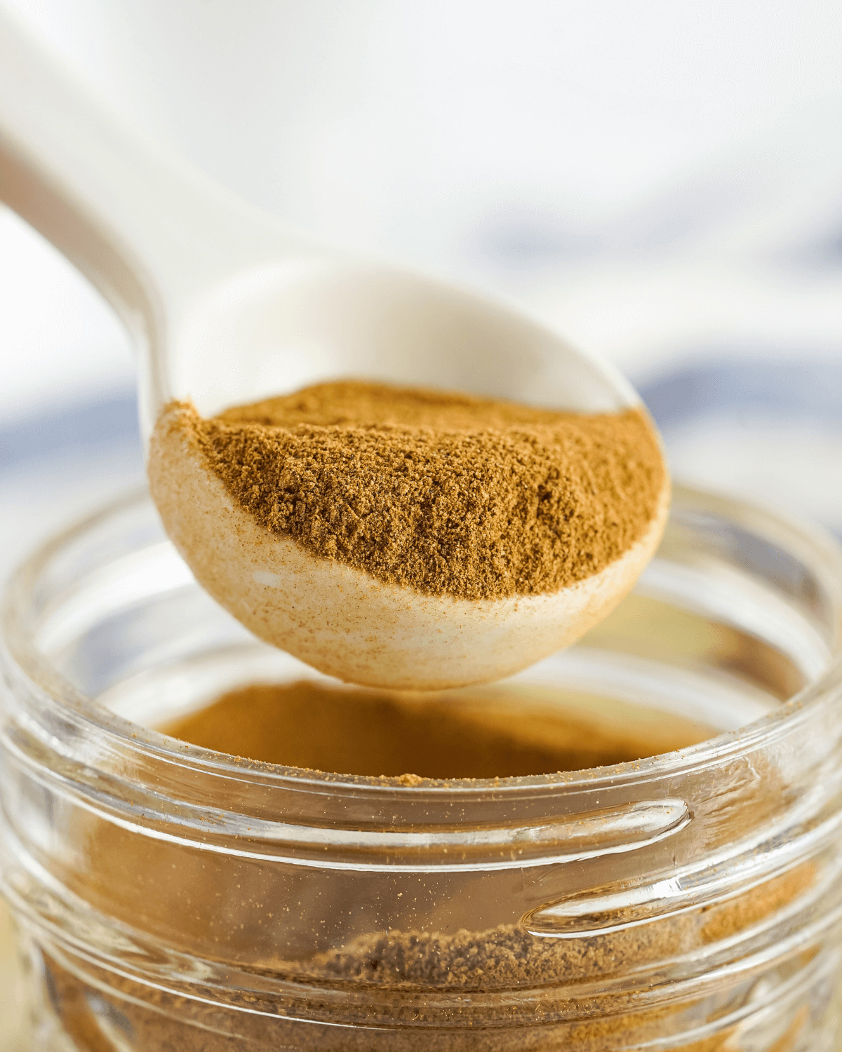 A spoon in the jar of aple pie spice.