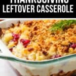 A glass baking dish filled with a Thanksgiving Leftovers Casserole, layered and topped with a golden breadcrumb crust, finished with a sprig of rosemary.