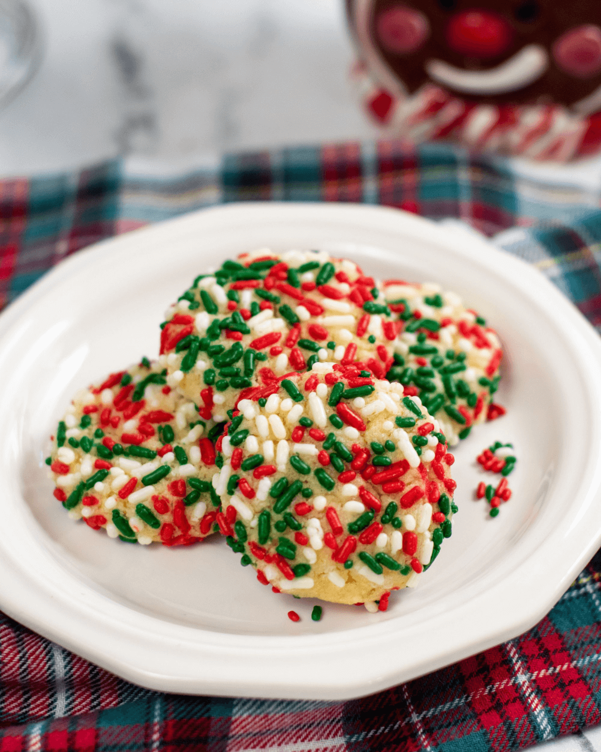 A white plate with sprinkle cookies. 