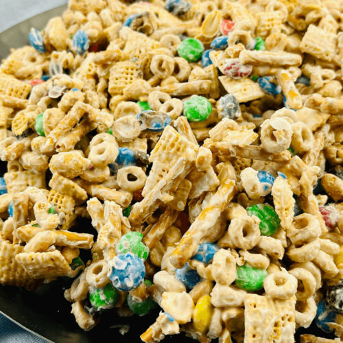 White chocolate chex mix on a black plate.