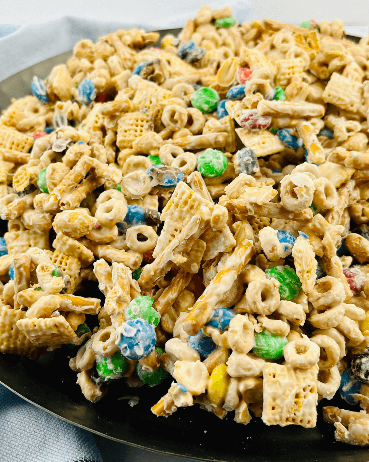 White chocolate chex mix on a black plate.
