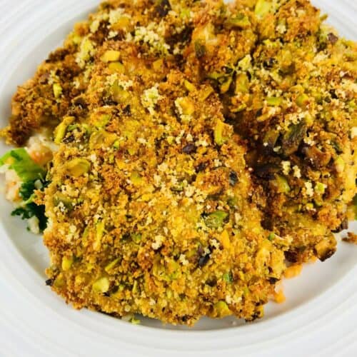 Pistachio-crusted chicken cutlets on a white plate, served similarly to an air fryer halibut.