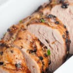 The cut meat with rosemary and thyme in a white dish.