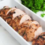 Air-fried chicken breasts on a white plate with parsley.