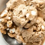 A bowl of ice cream with condensed milk and marshmallows.