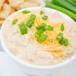 Cream cheese taco dip with chips and green onions.