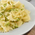 A plate of garlic butter pasta sauce with broccoli on it.