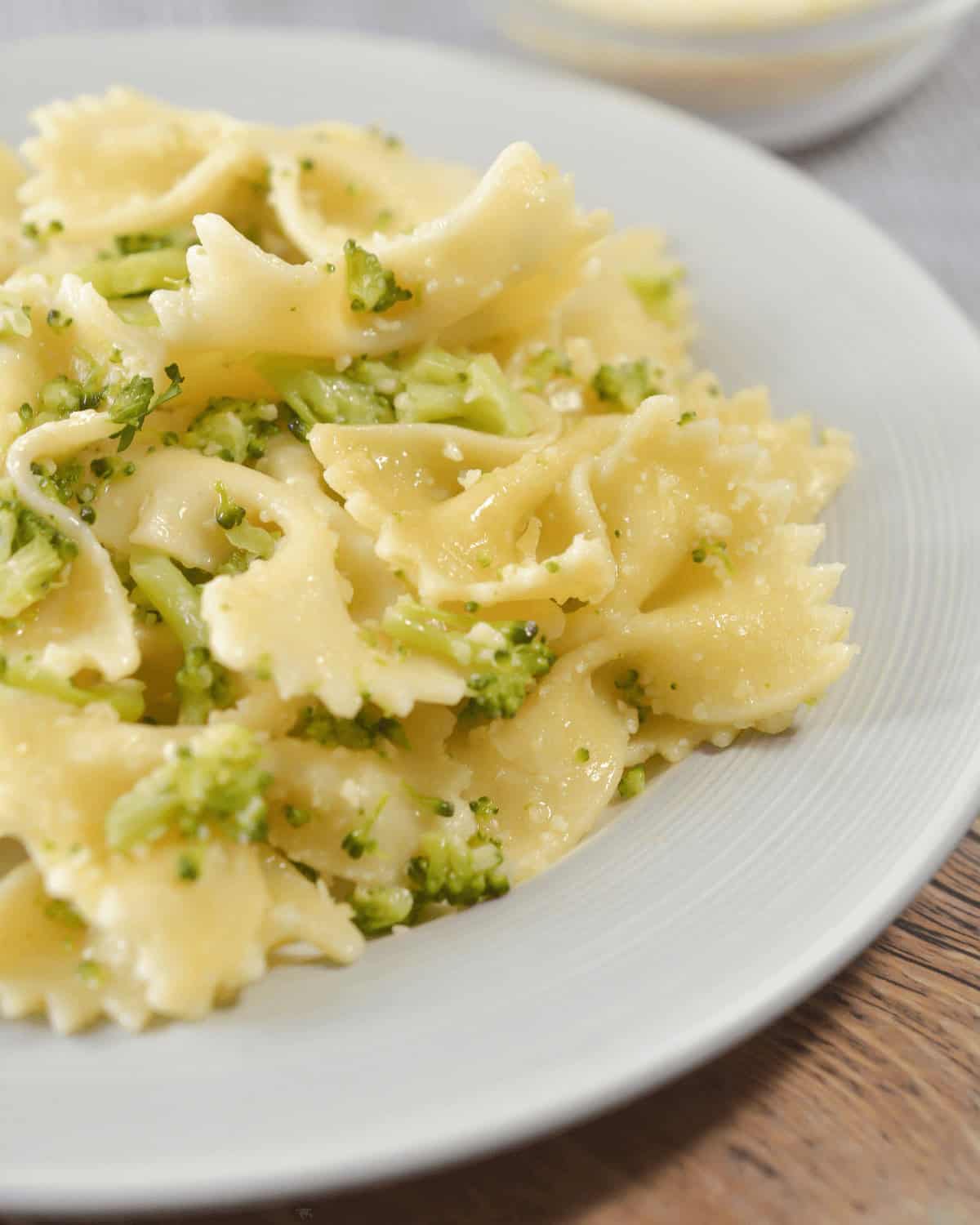 A plate of garlic butter pasta sauce with broccoli on it.