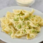 A plate of pasta with garlic butter pasta sauce and broccoli on it.