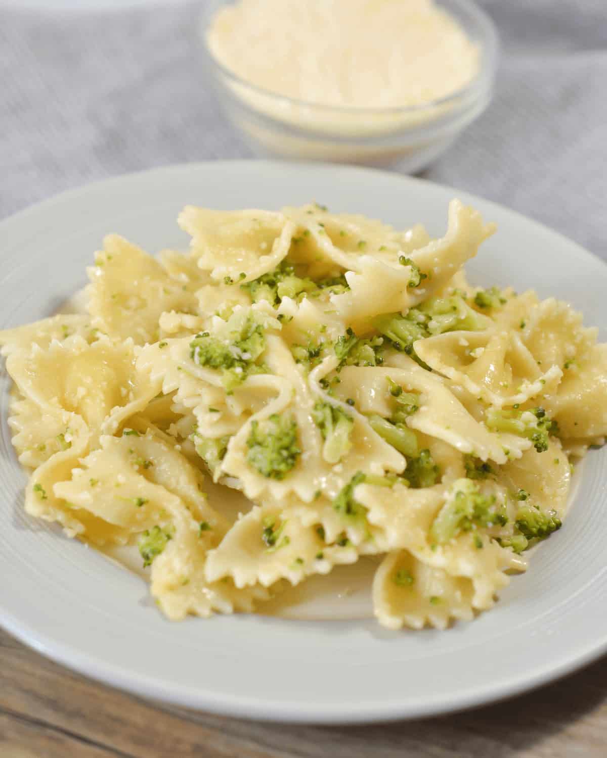 A plate of pasta with garlic butter pasta sauce and broccoli on it.