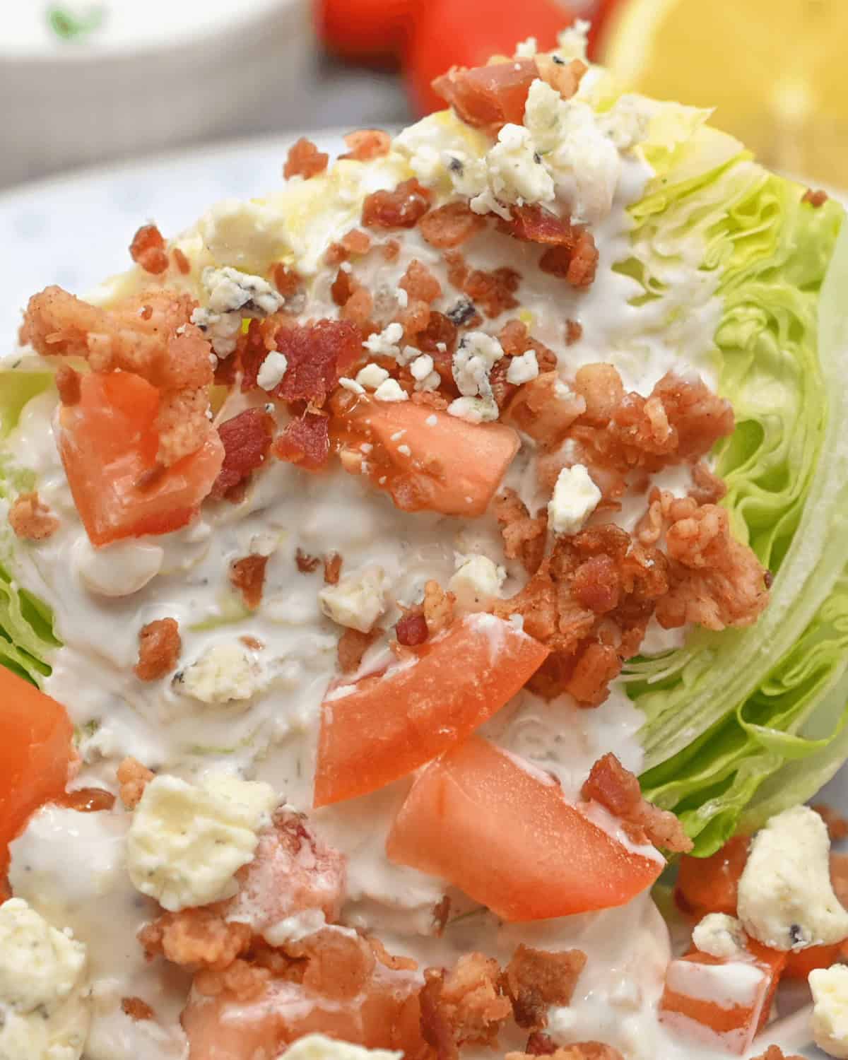 A Wedge Salad Recipe featuring a plate with lettuce, tomatoes, and bacon on it.