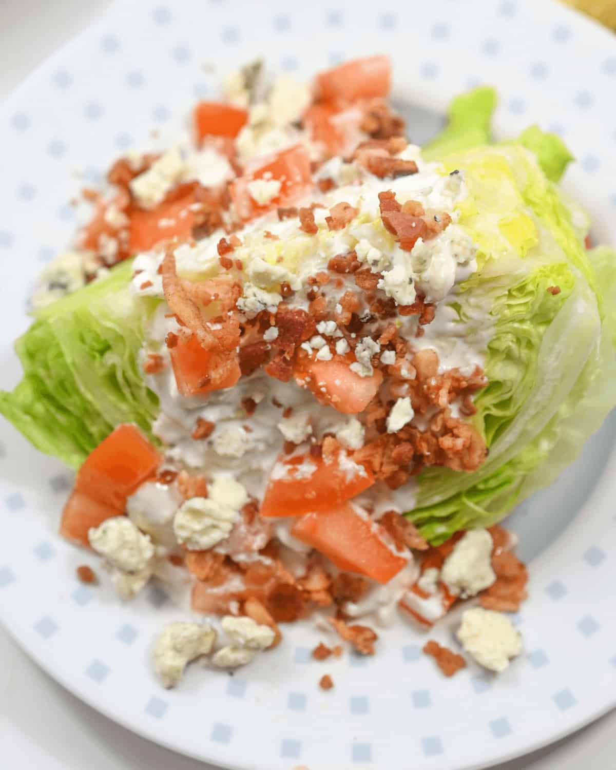  A plate with lettuce, tomatoes, and cheese on it.
