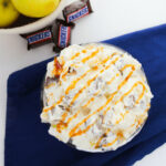 Apple Snickers Salad, a delicious combination of crisp apples, creamy ice cream, and drizzled caramel sauce.