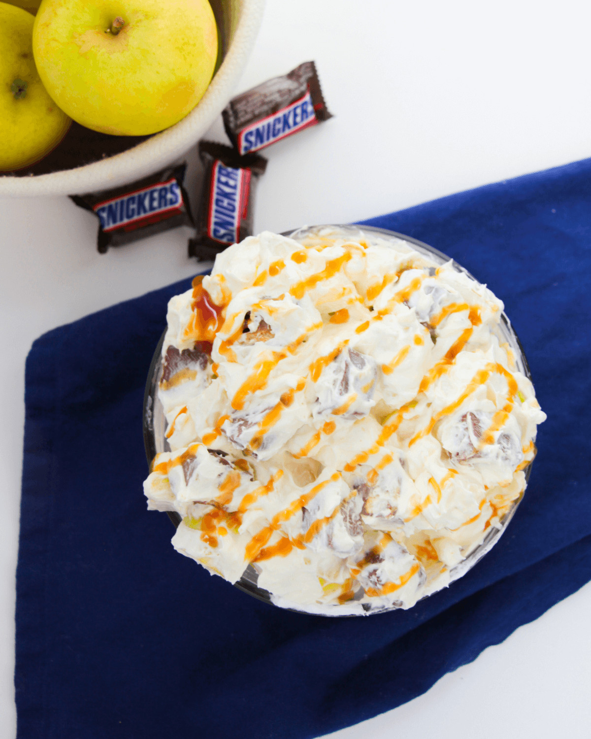 Apple Snickers Salad, a delicious combination of crisp apples, creamy ice cream, and drizzled caramel sauce.