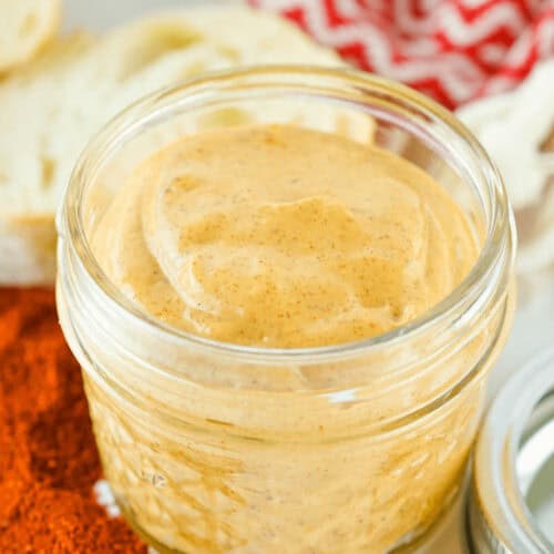 A jar of chipotle mayo on a white plate.