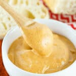 A white bowl with a spoon in it, filled with delicious Chipotle Mayo.