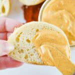 A person is dipping a spoon into a jar of Chipotle Mayo.