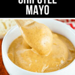 Chipotle mayo, the perfect blend of smoky chipotle peppers and creamy mayo, is served in a bowl accompanied by a spoon for easy enjoyment.