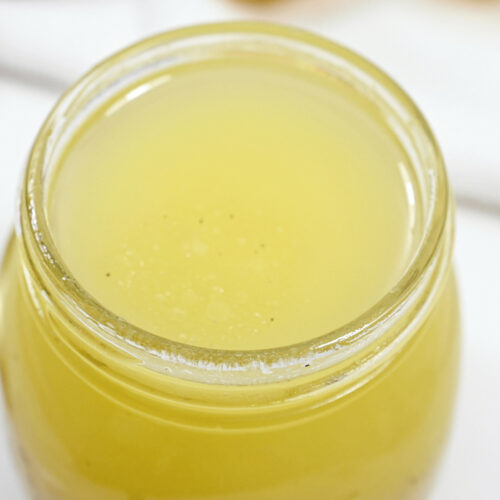 A jar of Citrus Vinaigrette on a white table.