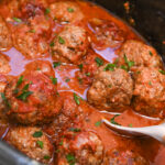 Italian sausage meatballs in tomato sauce cooked in a crock pot.
