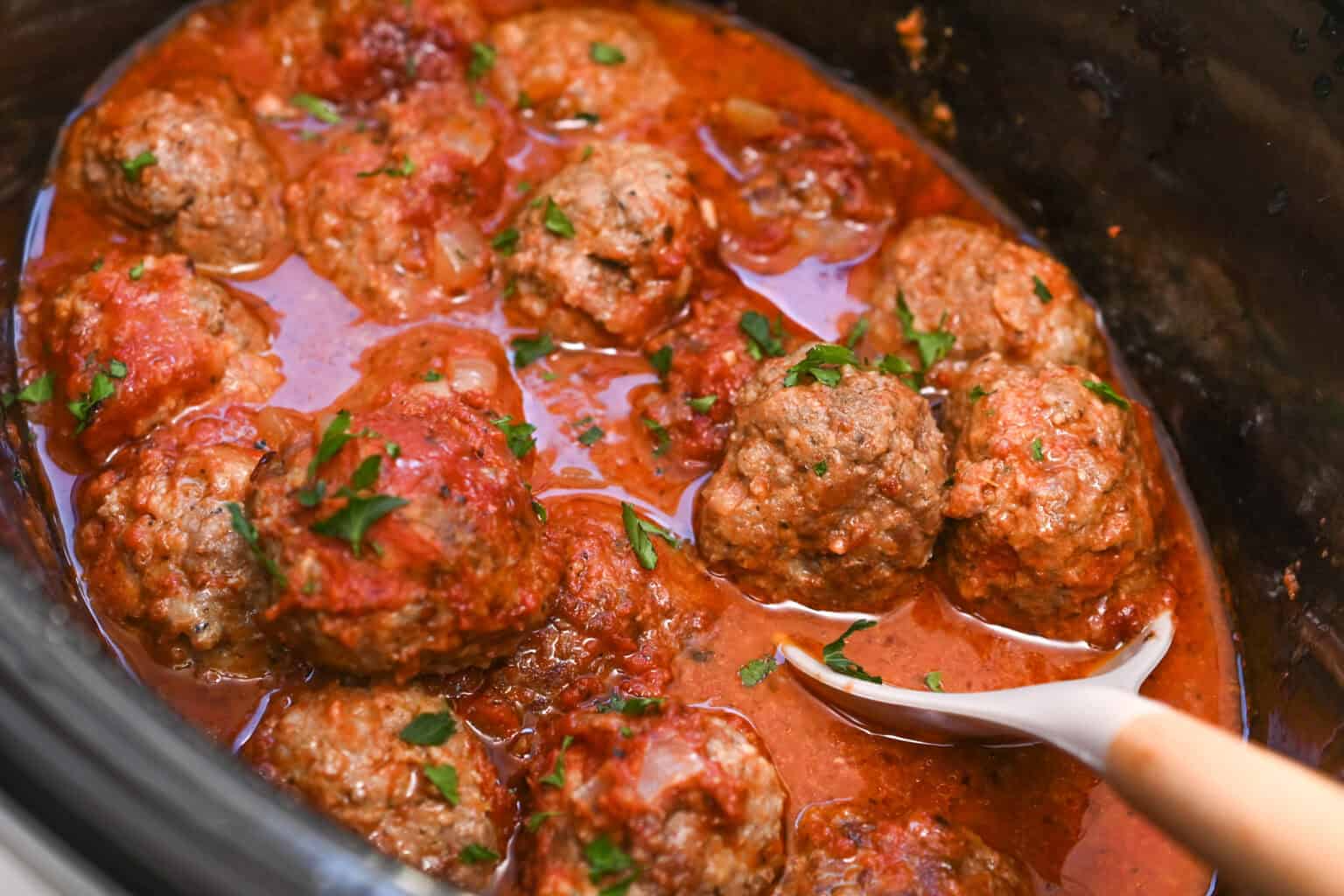 Italian sausage meatballs in tomato sauce cooked in a crock pot.