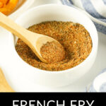 In a bowl with a wooden spoon, there is French fry seasoning.