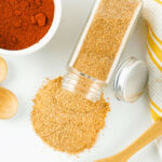 Homemade seasoned salt and other spices on a white table.